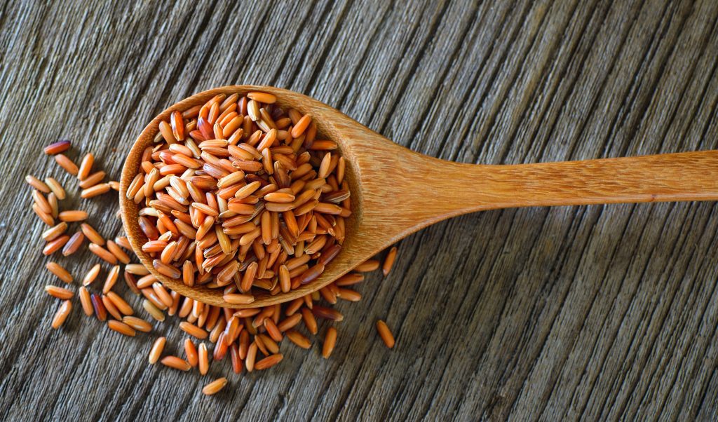 Brown rice in wood spoon on table. Brown rice for 7-Day Rice Diet Plan