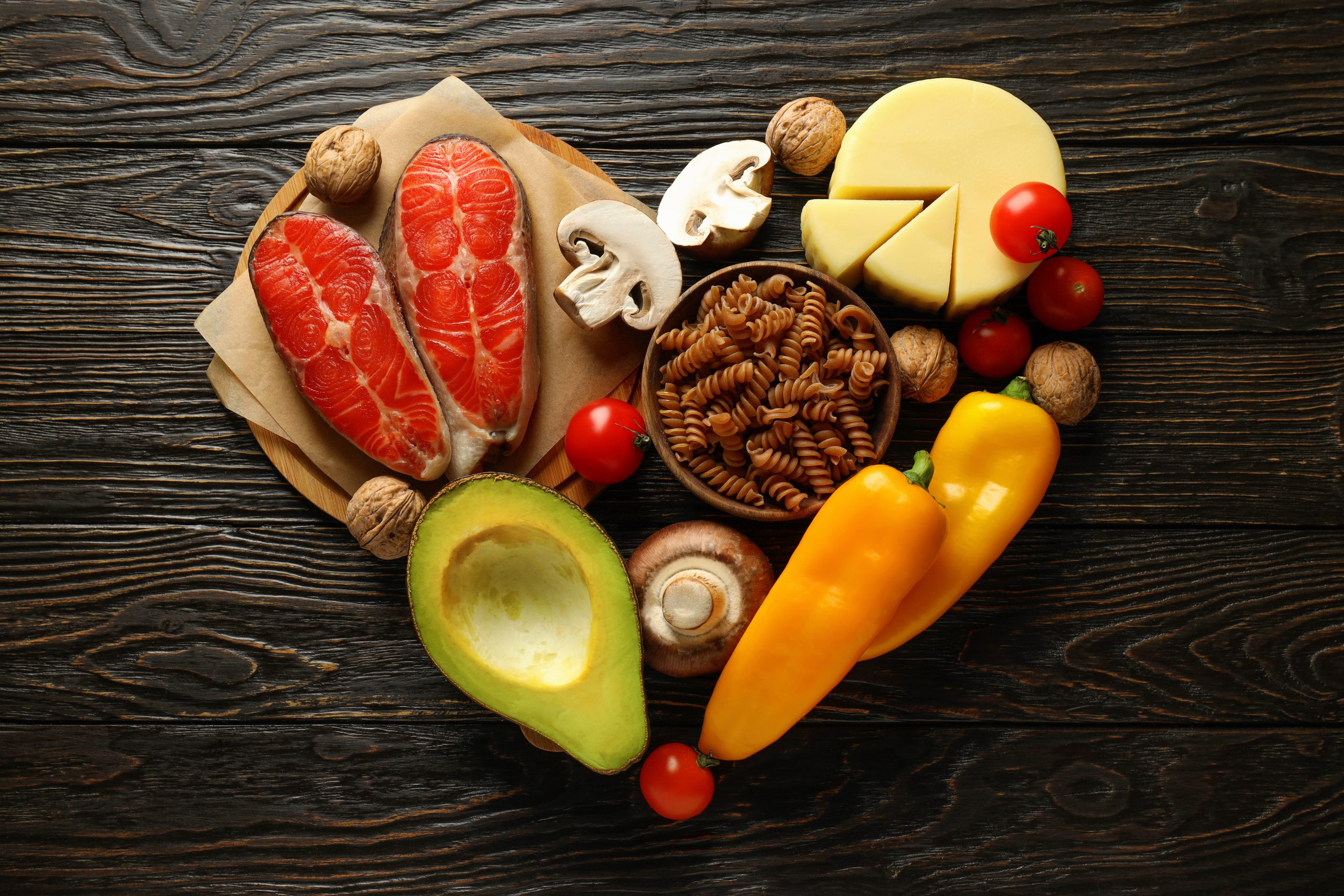 Illustration of the keto diet and heart disease impact, featuring healthy fats like avocados, nuts, and olive oil, alongside a heart symbol to represent heart health.